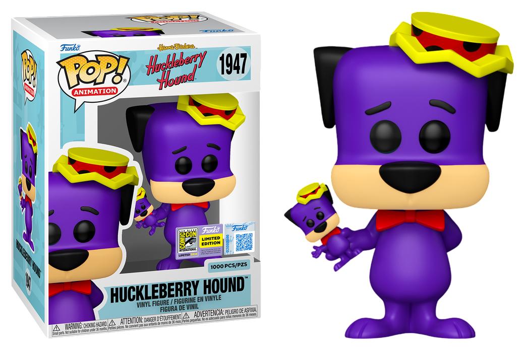 Boxed purple vinyl dog figure with yellow cap and red bow tie, plus small accessory
