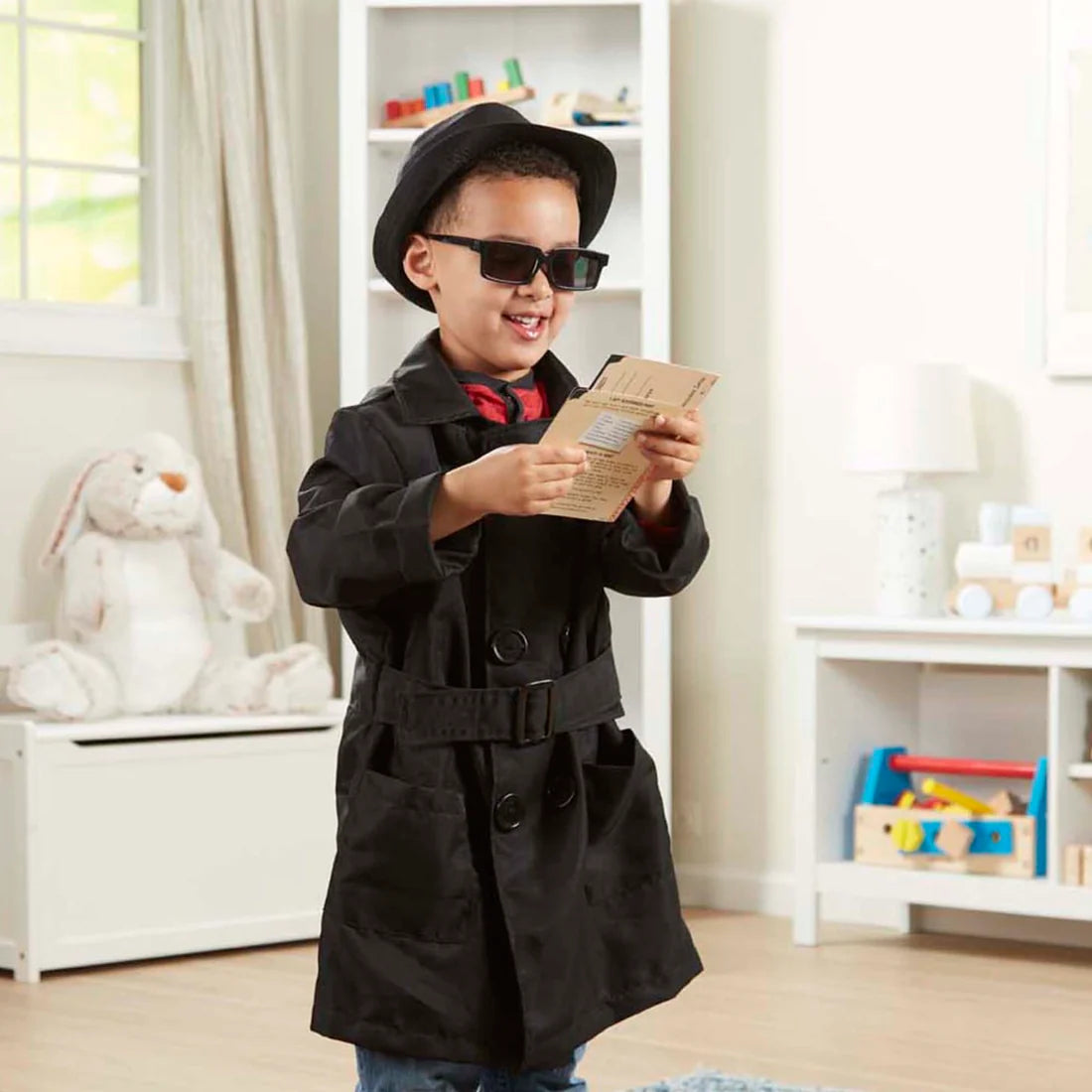 Kids black spy costume coat with belt and fedora hat, holding a secret message card